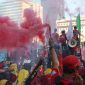 Sejumlah buruh menyalakan bom asap saat menutup aksi Hari Buruh Internasional di Jalan Medan Merdeka Barat, Jakarta, Rabu (5/1/2019). Aksi May Day 2019 di Jakarta ditutup oleh buruh dengan menyalakan kembang api sebagai simbol berjalannya demo dengan damai (foto istimewa)