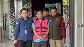 Ketua Ombudsman RI Hery Susanto saat keluar dari Gedung Bundar Jaksa Agung Muda Tindak Pidana Khusus (Jampidsus) Kejagung sekitar pukul 11.19 WIB. Ia mengenakan kaos berlogo PLN yang dilapisi rompi tahanan berwarna merah muda khas Kejaksaan dengan tangan terborgol (Dok.istimewa) 