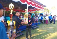 Ketua Askab PSSI Manggarai Barat, Marianus Yono Jehanu menyerahkan piala kepada Ketua Panitia (Dok.istimewa)