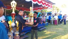 Ketua Askab PSSI Manggarai Barat, Marianus Yono Jehanu menyerahkan piala kepada Ketua Panitia (Dok.istimewa)