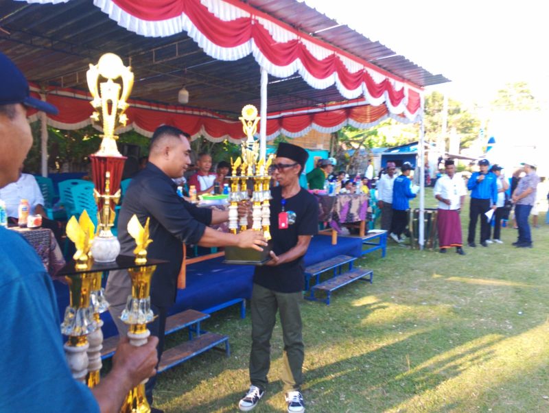 Ketua Askab PSSI Manggarai Barat, Marianus Yono Jehanu menyerahkan piala kepada Ketua Panitia (Dok.istimewa)