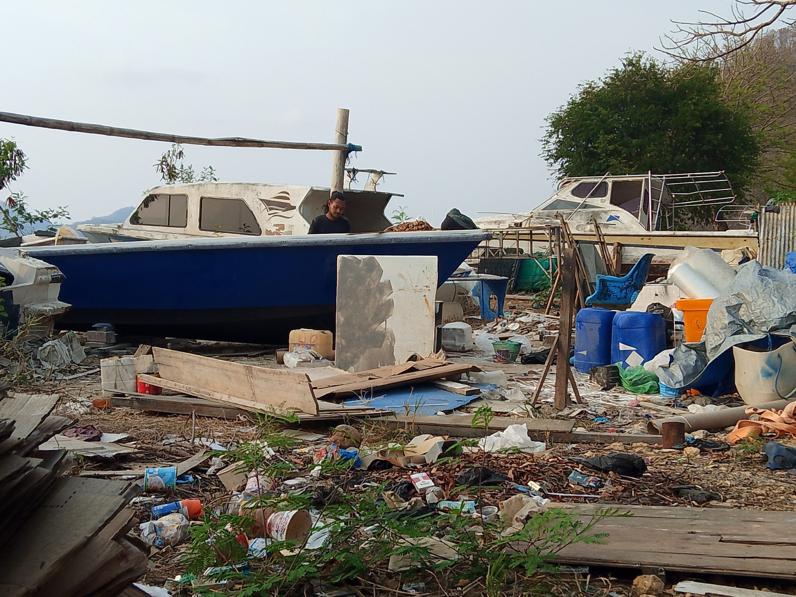 Bangkai kapal, kaleng cat dan sampah dibiarkan di pinggir pantai (Foto:Doc.Deni)